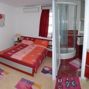 a small bedroom with a bed and a shower at Guesthouse Vila Nova in Morović