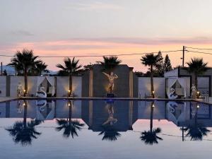 a pool with a statue in the middle of it at Paradice Hotel Luxury Suites-Near zorbas Beach-FREE Breakfast in Stavros