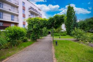 a sidewalk in front of a building with a tree at Appartement cosy aux portes de Paris in Aubervilliers