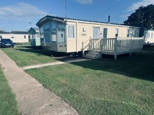 a mobile home with a porch on the grass at 8 Berth Caravan For Hire Near Clacton-on-sea In Essex Ref 26287e in Clacton-on-Sea