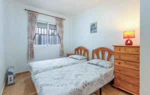 a bedroom with two beds and a dresser and a window at 2 Bedroom Beautiful Home In Castalla in Castalla +10 photos