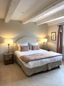 a bedroom with a large bed with two lamps at Les Restanques De Beaudine in Forcalquier