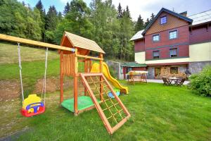 a playground with a slide and a swing at Pension Silva in Špindlerův Mlýn