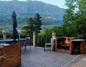 a patio with a fireplace with a table and chairs at Home SG jato in San Giuseppe Iato