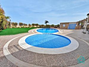 a swimming pool with blue water in the middle at Retiro Zen en Tu Rincón Mediterráneo in Oropesa del Mar