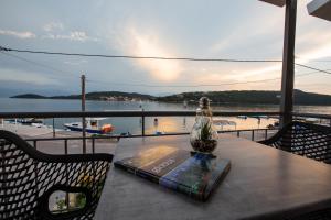 a book on a table with a view of the water at Haris Suites in Glyfada Fokidas