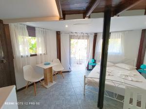 a bedroom with a bed and a table and chairs at Spasmata Village - Marios Bungalows Only Adults 2 min From The Beach in Minia +11 photos