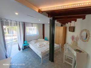 a bedroom with a bed and a table and chairs at Spasmata Marios bungalows in Minia