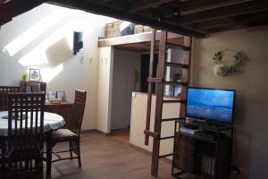 a room with a loft bed with a television and a table at Le perchoir de St-Antoine in Honfleur