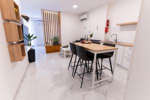 a kitchen with a wooden table and black chairs at Stylish place in St Julians in St. Julianʼs +17 photos