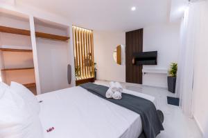 a bedroom with a white bed and a television at Stylish place in St Julians in St. Julianʼs