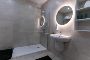 a bathroom with a sink and a mirror at Stylish place in St Julians in St. Julianʼs