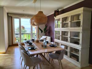 a dining room with a wooden table and chairs at Chalet jardin privado, Piscina Comunit, Max 10 pers in Sanxenxo