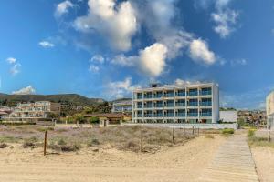 a building on the beach next to a sandy beach at Apartamentos Azul in Castelldefels