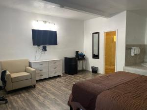 1 dormitorio con 1 cama, 1 silla y TV en Big Pines Mountain House, en South Lake Tahoe