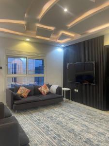 a living room with a couch and a flat screen tv at إطلالة الشرق شقة خاصة 13 كلم عن الحرم East View 13 KM away from Alharam in Al Madinah