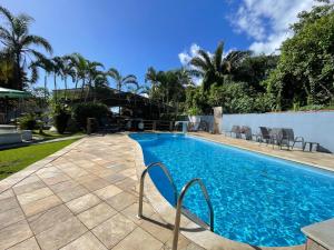 Una piscina con agua azul en un patio. en Pousada PÍER 22, en Caraguatatuba