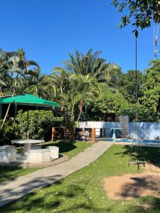 a park with a picnic table and a pool at Pousada PÍER 22 in Caraguatatuba