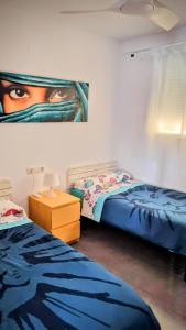 a bedroom with two beds and a painting on the wall at Hello Piles Beach Javier in Piles +40 photos
