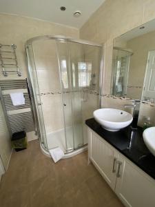 La salle de bains est pourvue d'une douche en verre et d'un lavabo. dans l'établissement Bellvue Party House, à Pollington