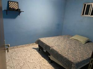 a bedroom with a bed in a blue room at Casa confortável com 3 quartos in Bonito