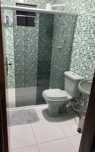 a bathroom with a shower with a toilet and a sink at Casa confortável com 3 quartos in Bonito