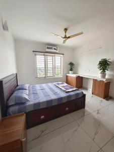 a bedroom with a bed and a ceiling fan at Luxurious Apartment with a pool and gym near Trivandrum railway station in Trivandrum
