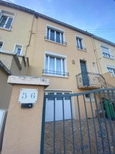 un bâtiment avec une horloge sur le côté dans l'établissement Chambre double 10 min du circuit, à Allonnes