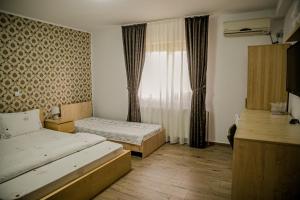 a hotel room with two beds and a window at Vila Rafael si Robert in 2 Mai