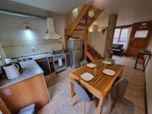 Una cocina y un comedor con mesa y sillas de madera. en Paimun 2 - Andarlibre, en San Martín de los Andes