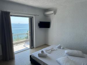 a bedroom with a bed with a view of the ocean at Aqua Apartments in Loutra Oraias Elenis