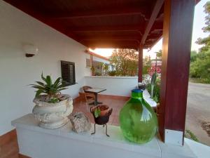 a green vase sitting on top of a porch at Casa Colonica Liliane B&B in Porto Cesareo
