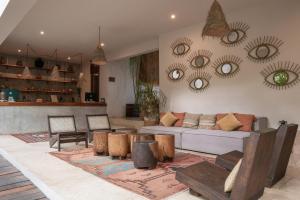 a living room with a couch and mirrors on the wall at Hotel Casa Hormiga in Bacalar