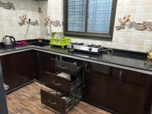 a kitchen with wooden cabinets and a counter with a sink at Duja Homes in Maihar