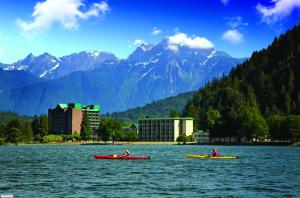 two people in kayaks on a lake with mountains at Harrison Hot Springs Resort & Spa in Harrison Hot Springs