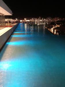 a large pool of blue water at night at A casa SCALILLA in Palermo