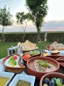 a table with several bowls of food on it at Al Malfa Resort in Unayzah