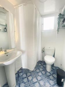 a white bathroom with a sink and a toilet at Charming apartment in Central Medina of Tetuan15 min airport in Tetouan
