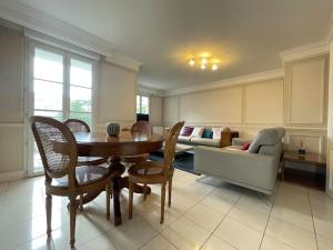 a living room with a table and a couch at Spacious Marie apt in Serris