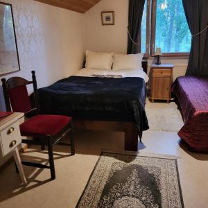 a bedroom with a bed and a chair and a window at Kotimajoitus Noora in Pori