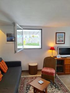 a living room with a couch and a chair at Appartement moderne avec terrasse - proche mer in Agon Coutainville