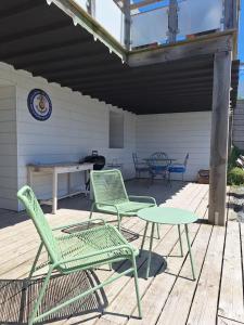 a patio with two chairs and a table on a deck at Appartement moderne avec terrasse - proche mer in Agon Coutainville