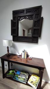 une table en bois avec un miroir sur un mur dans l'établissement Gîte 4 pers L'Ainstant Présent, à Ambérieux-en-Dombes 3 autres photos
