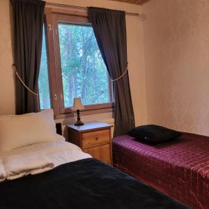 a bedroom with two beds and a window at Kotimajoitus Noora in Pori