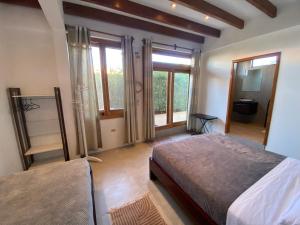 1 dormitorio con 2 camas y ventanas grandes en Black Pearl, en Puerto Villamil