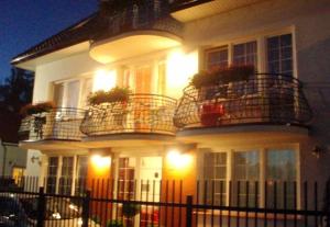 a white house with two balconies and lights on it at Giselle in Mielno