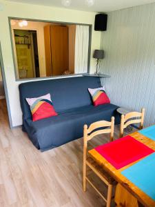 a blue couch in a living room with a table at Studio pied de pistes Tour de la Biche in Besse-et-Saint-Anastaise