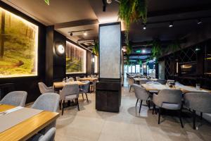 a restaurant with tables and chairs and a large screen at Fabesca Boutique Hotel & SPA in Sovata