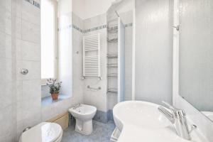 a white bathroom with a toilet and a sink at Casa Elena in Rome