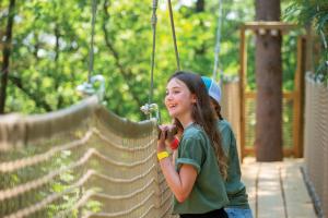 a young girl on a zip line at a playground at Natura Treescape Resort in Wisconsin Dells